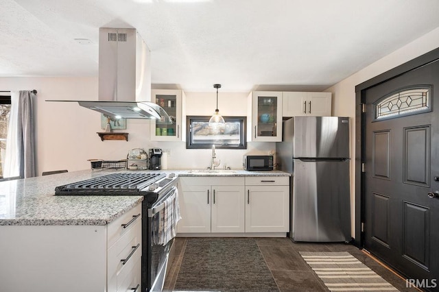 kitchen featuring glass insert cabinets, appliances with stainless steel finishes, a peninsula, island range hood, and a sink