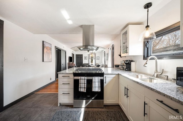 kitchen featuring stainless steel range with gas cooktop, light stone countertops, a peninsula, island range hood, and a sink