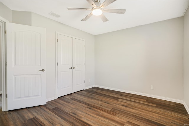 unfurnished bedroom featuring a ceiling fan, visible vents, baseboards, dark wood-style flooring, and a closet