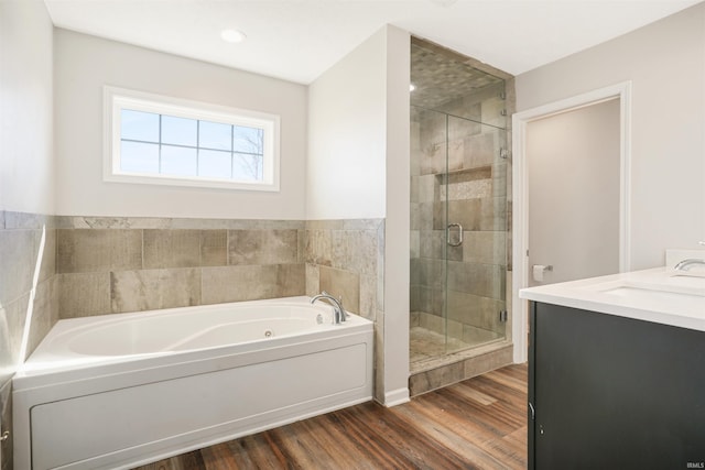 full bathroom with vanity, a jetted tub, wood finished floors, and a stall shower