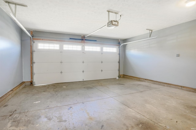 garage with a garage door opener and baseboards