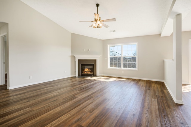 unfurnished living room with visible vents, dark wood-type flooring, baseboards, a fireplace with flush hearth, and a ceiling fan