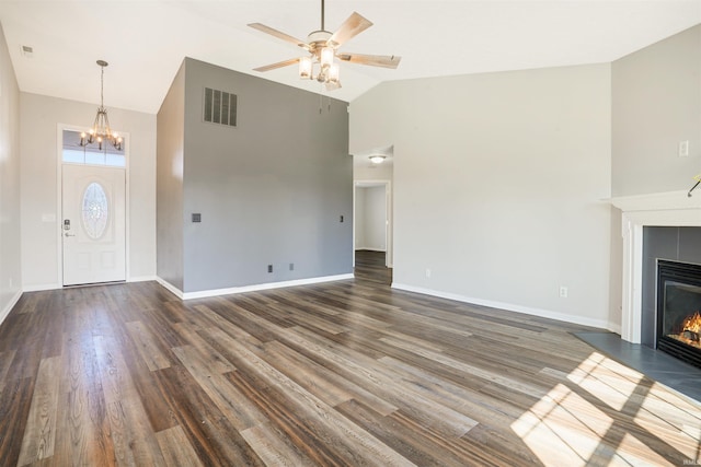 unfurnished living room featuring a tiled fireplace, dark wood-style floors, visible vents, and high vaulted ceiling