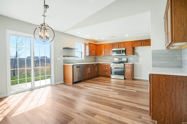 kitchen with brown cabinetry, light wood-style flooring, stainless steel appliances, and light countertops