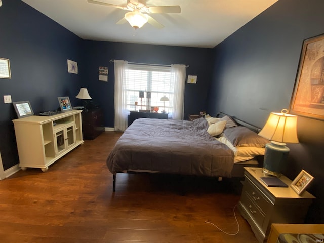 bedroom with a ceiling fan, baseboards, and wood finished floors