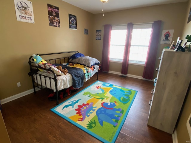 bedroom featuring wood finished floors and baseboards