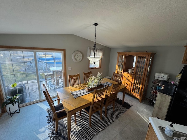 dining room with lofted ceiling and a textured ceiling