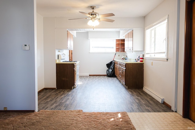 kitchen with a wealth of natural light, a baseboard heating unit, white gas stove, and dark wood-style flooring