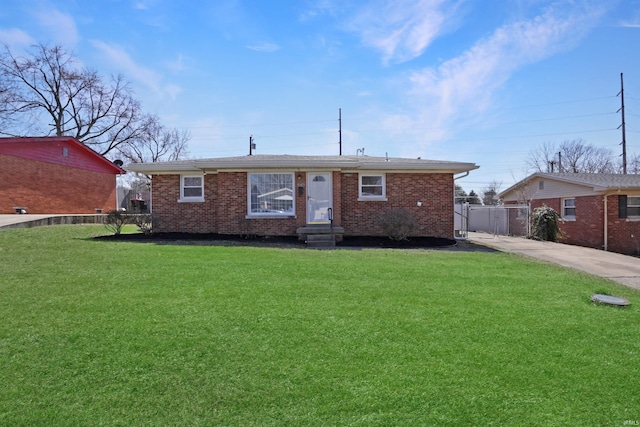 view of front of house with brick siding, a front yard, and fence