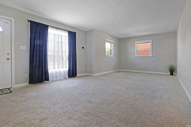 carpeted spare room with baseboards