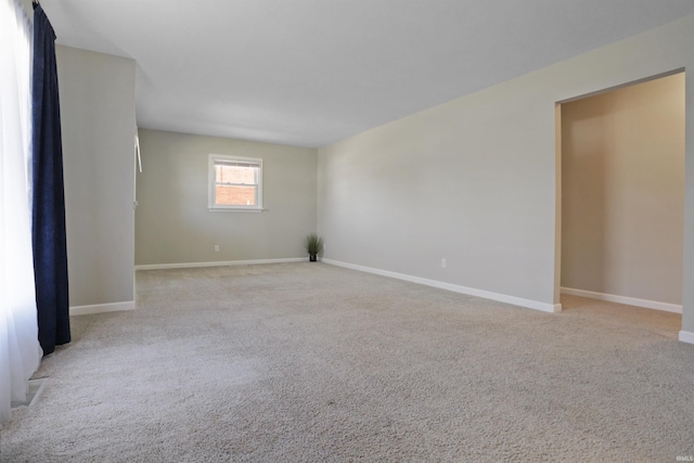 empty room featuring baseboards and carpet