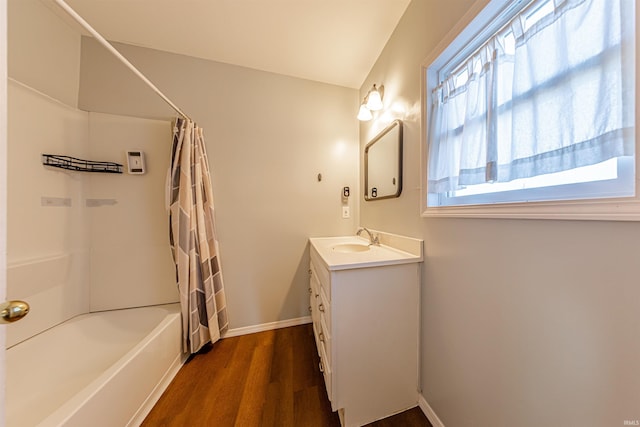 full bathroom with vanity, wood finished floors, baseboards, and shower / tub combo with curtain