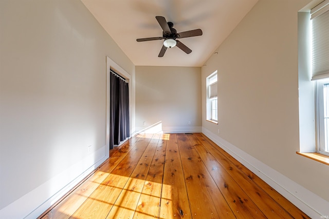 empty room with baseboards, wood-type flooring, and ceiling fan