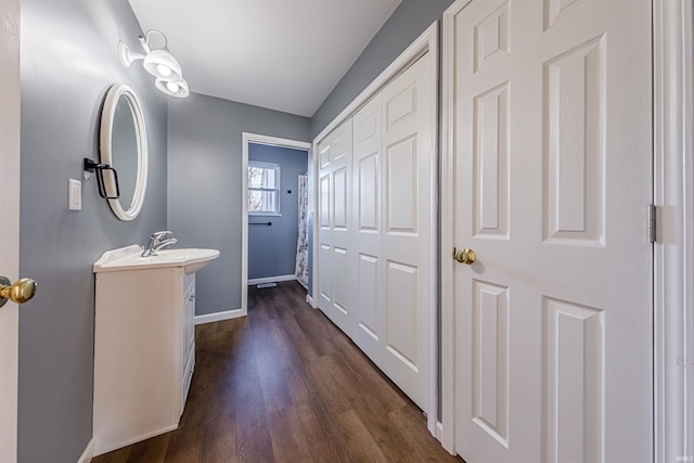 bathroom featuring vanity, baseboards, and wood finished floors