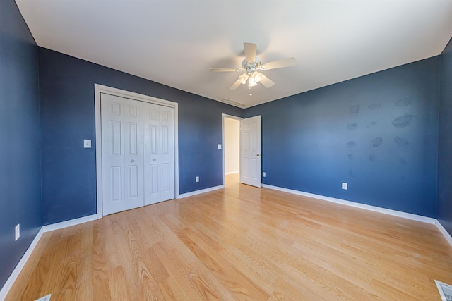 unfurnished bedroom featuring light wood finished floors, ceiling fan, a closet, and baseboards