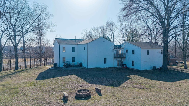 back of house with a lawn, an outdoor fire pit, and a patio