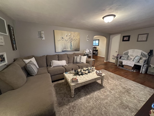 living area with arched walkways and wood finished floors