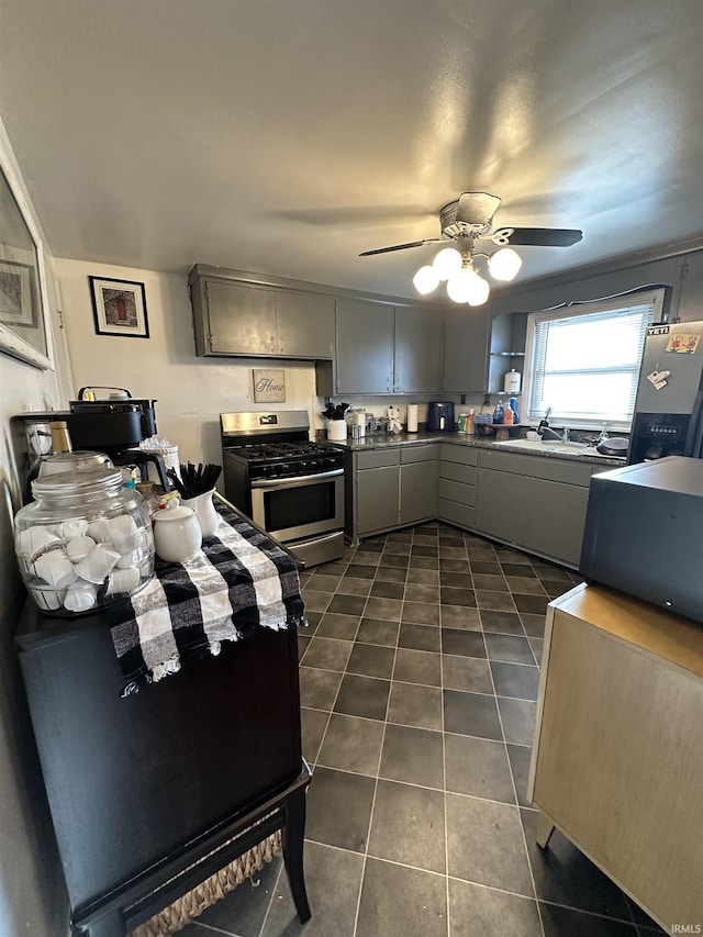 kitchen featuring a sink, dark tile patterned flooring, gray cabinetry, and stainless steel appliances