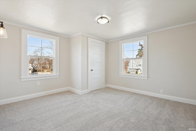 unfurnished bedroom featuring baseboards, multiple windows, light colored carpet, and crown molding