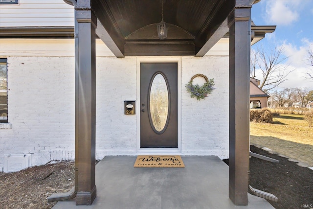 property entrance featuring brick siding and crawl space