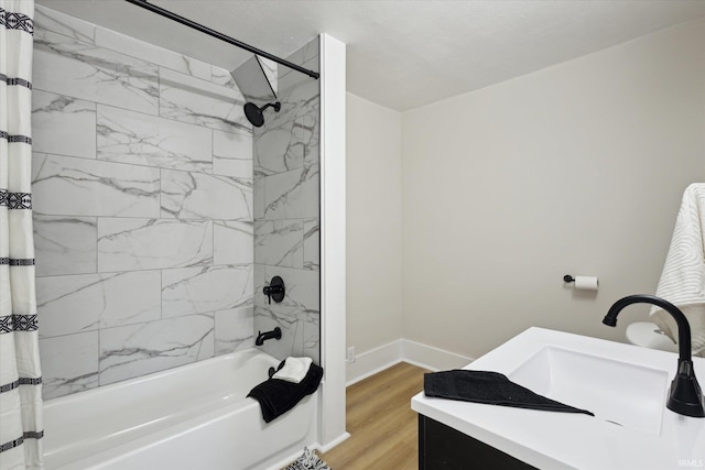 full bath featuring vanity, wood finished floors, baseboards, and shower / bath combo with shower curtain