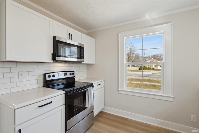 kitchen featuring light countertops, a wealth of natural light, tasteful backsplash, and appliances with stainless steel finishes