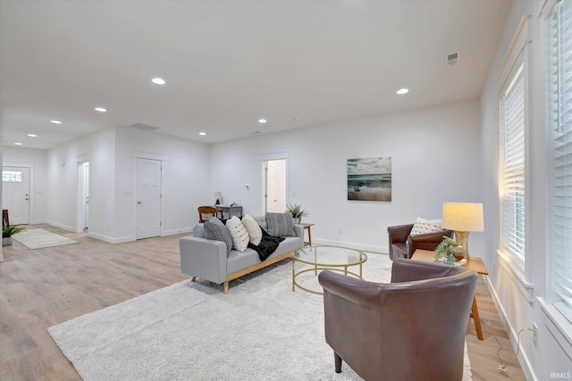 living room featuring a wealth of natural light, visible vents, recessed lighting, and light wood finished floors