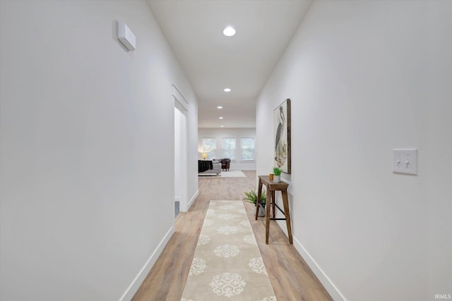 hall featuring recessed lighting, light wood-type flooring, and baseboards