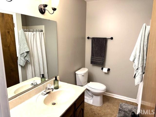 full bath featuring vanity, toilet, and baseboards