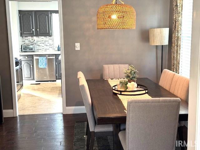 dining area with baseboards and wood finished floors