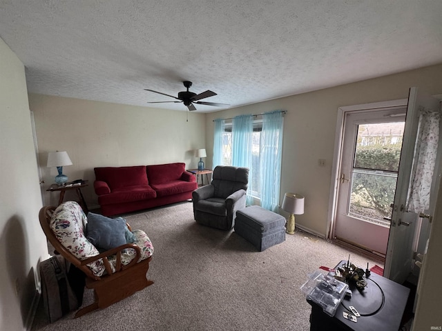 living room featuring carpet, a ceiling fan, and a textured ceiling