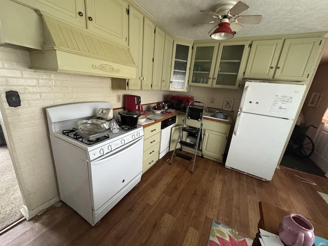 kitchen with custom exhaust hood, dark wood finished floors, white appliances, and a textured ceiling