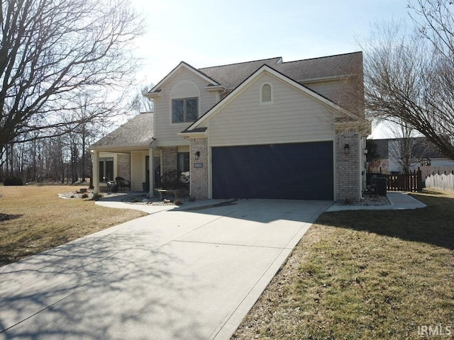 traditional-style home with fence, concrete driveway, a front yard, an attached garage, and brick siding