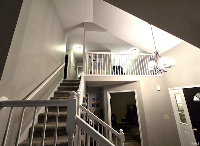 stairway with a notable chandelier and high vaulted ceiling