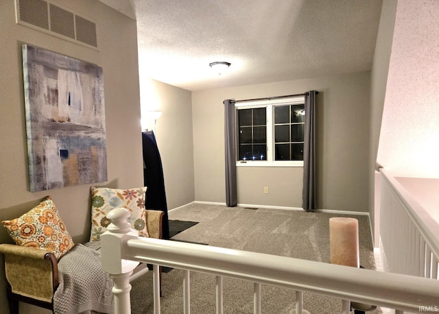 interior space featuring visible vents, baseboards, carpet, and a textured ceiling