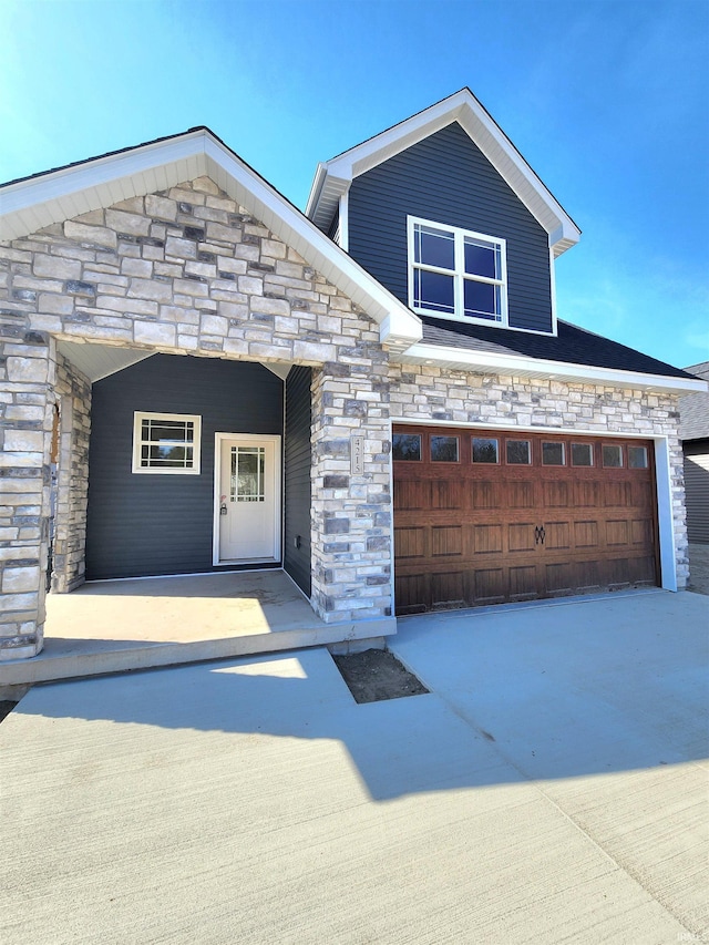 view of front facade with a garage and stone siding