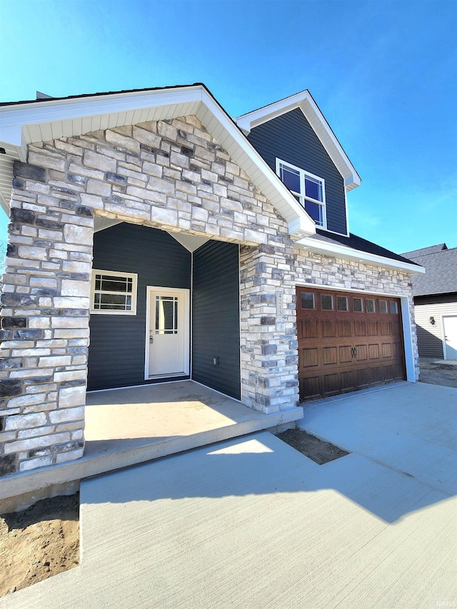 view of front of property featuring stone siding and driveway