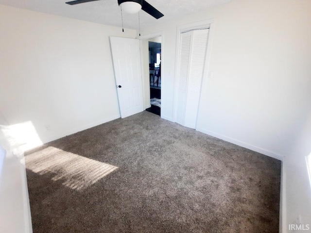 unfurnished bedroom with a ceiling fan, carpet, a closet, and baseboards