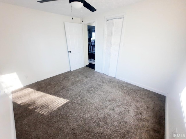 unfurnished bedroom featuring a closet, baseboards, ceiling fan, and carpet floors