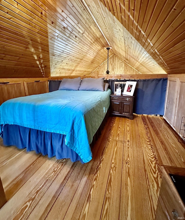 unfurnished bedroom featuring wooden walls, wood ceiling, wood finished floors, and vaulted ceiling