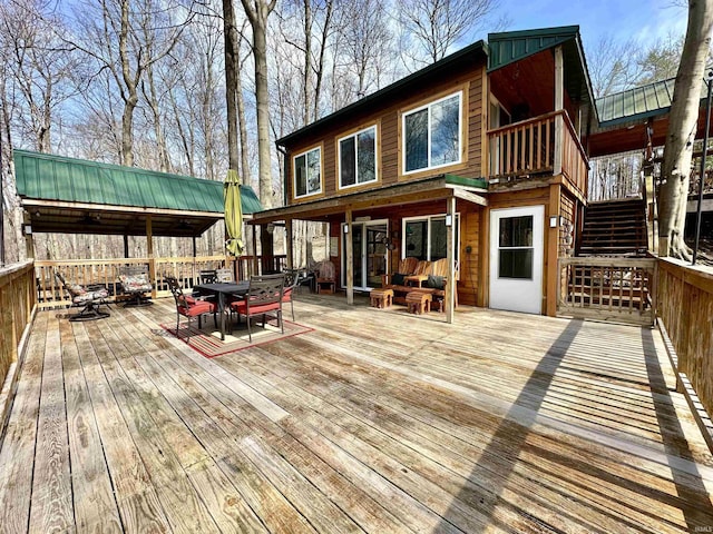 wooden deck featuring outdoor dining space and stairs