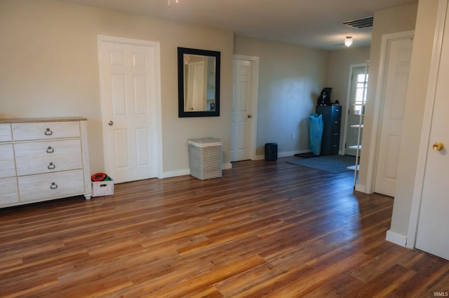 interior space featuring visible vents, baseboards, and wood finished floors