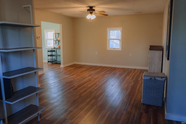 unfurnished living room featuring wood finished floors, baseboards, and a wealth of natural light