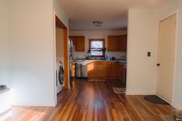 kitchen with baseboards, dishwasher, dark wood-style floors, brown cabinetry, and washer / clothes dryer