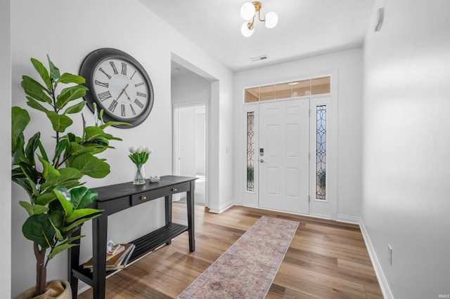 foyer with visible vents, light wood-style floors, and baseboards