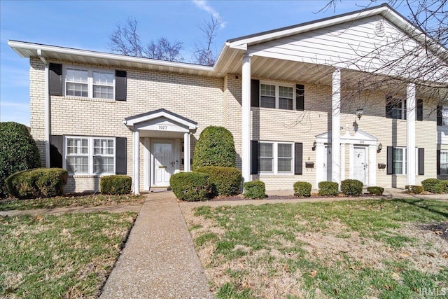 view of front of property featuring brick siding and a front yard