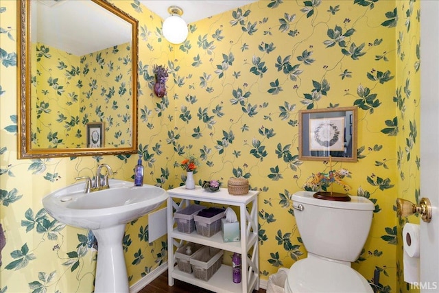 bathroom featuring wallpapered walls and toilet