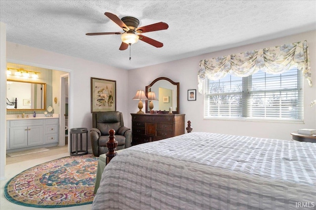 bedroom featuring ensuite bath, a textured ceiling, and ceiling fan