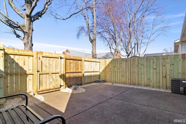 view of patio featuring a gate, central AC unit, and fence