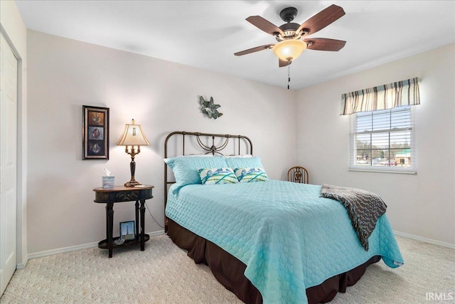 carpeted bedroom with a ceiling fan and baseboards